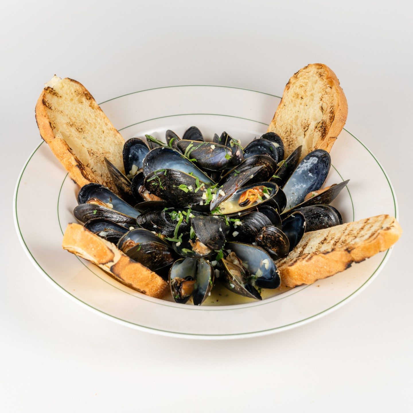 A bowl of mussels with toasted bread, ready to order online